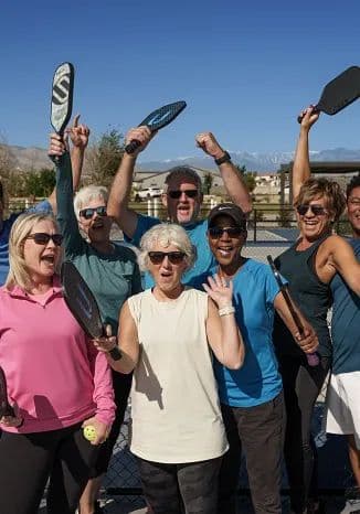 Pickleball group cheering with paddles up