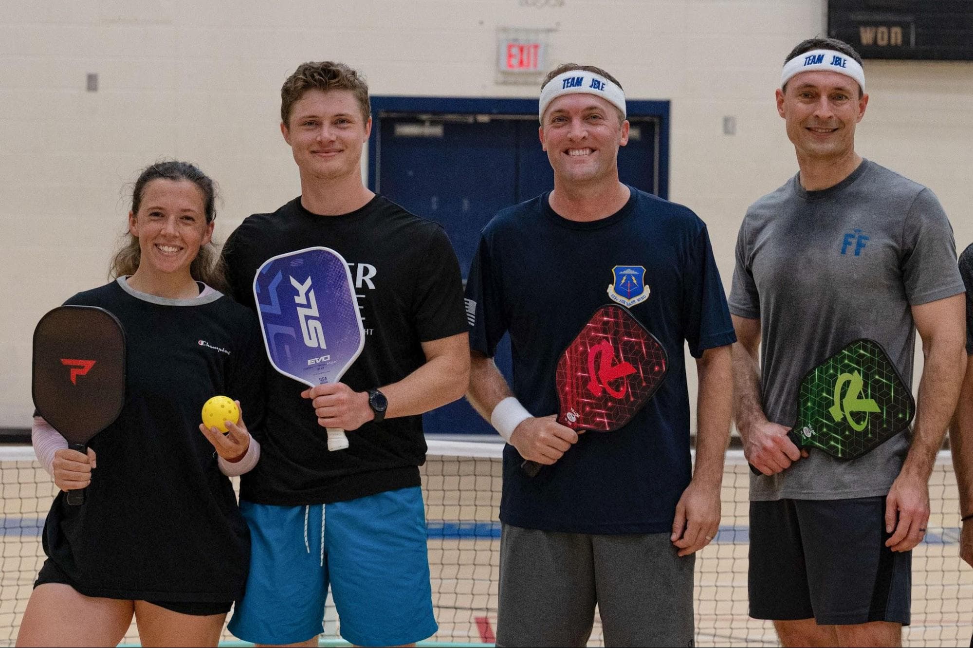 Four pickleball players with their paddles